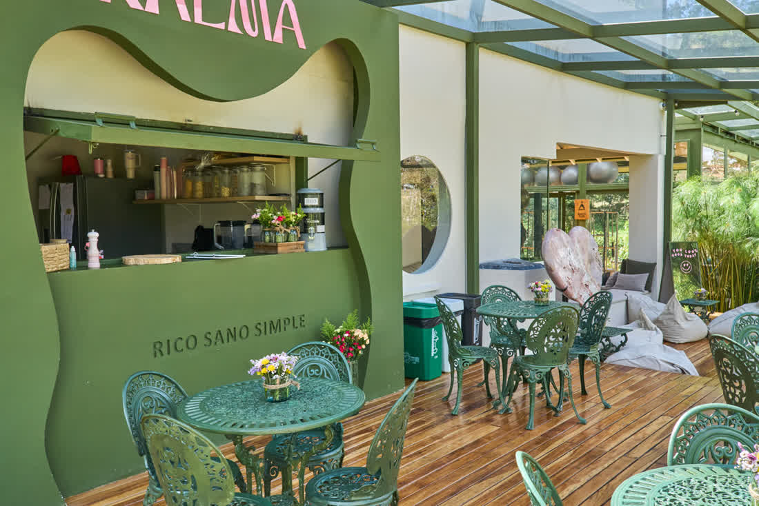 Terraza del café Seralma con mesas verdes y jardín
